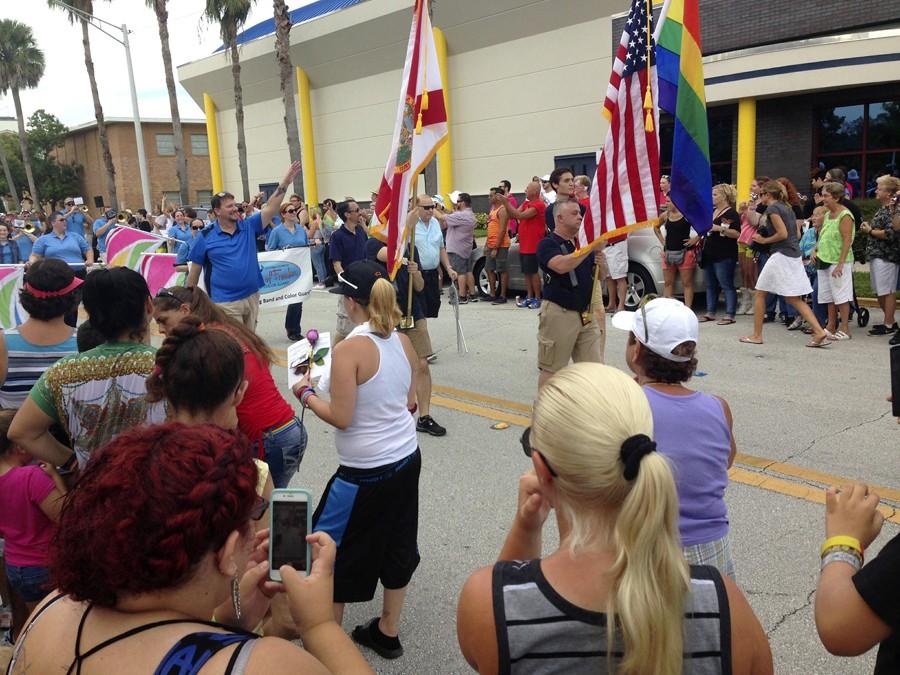 Parade-goers rally with government and LGBT flags as they march in Space Coast Pride’s first ever Gay Pride Parade in the Eau Gallie Art District on Sept. 26.