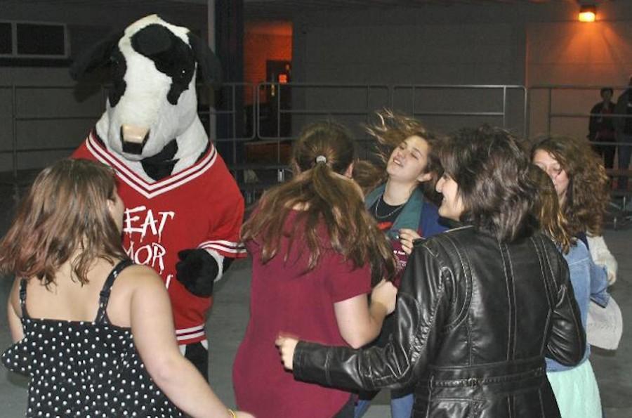 Dancing to Lets Twist Again, Melanie Richardson and Sarah Porhammer groove with the Chick fila mascot last year.