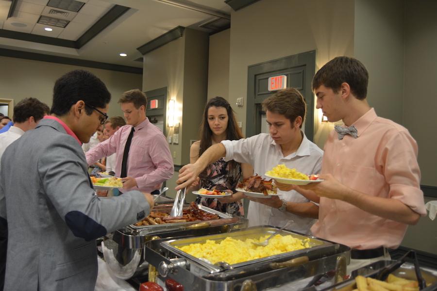 Kassie West, Stryker Sinclair, and Ben Mechachonis get food during the 2014 Senior Breakfast.