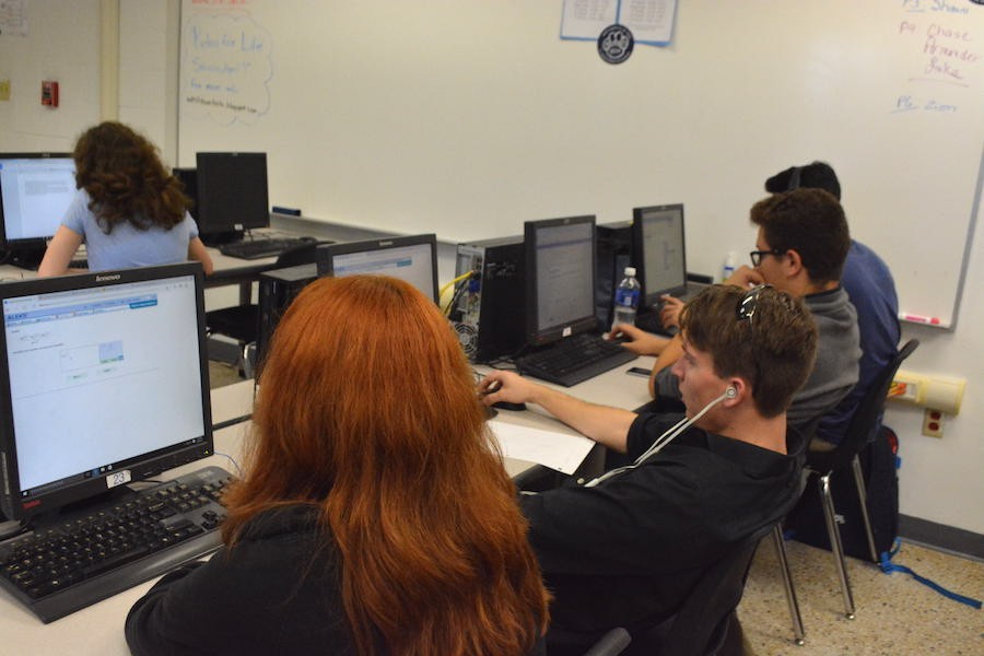 Working in an online virtual lab classroom, several students fulfill their online requirement in order to graduate. 