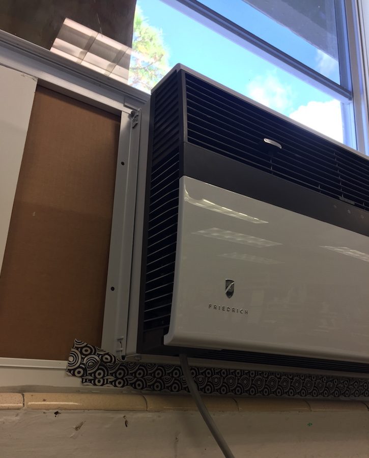 A portable window-unit air conditioner has been installed in the art while while parts are on order.