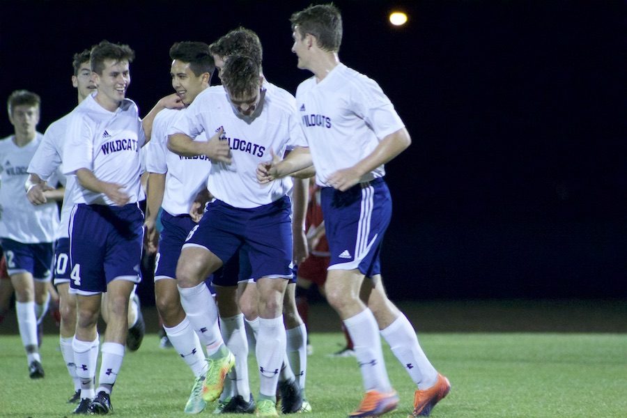 Senior Nick Burgess celebrates with his team after making a free kick Wednesday night.