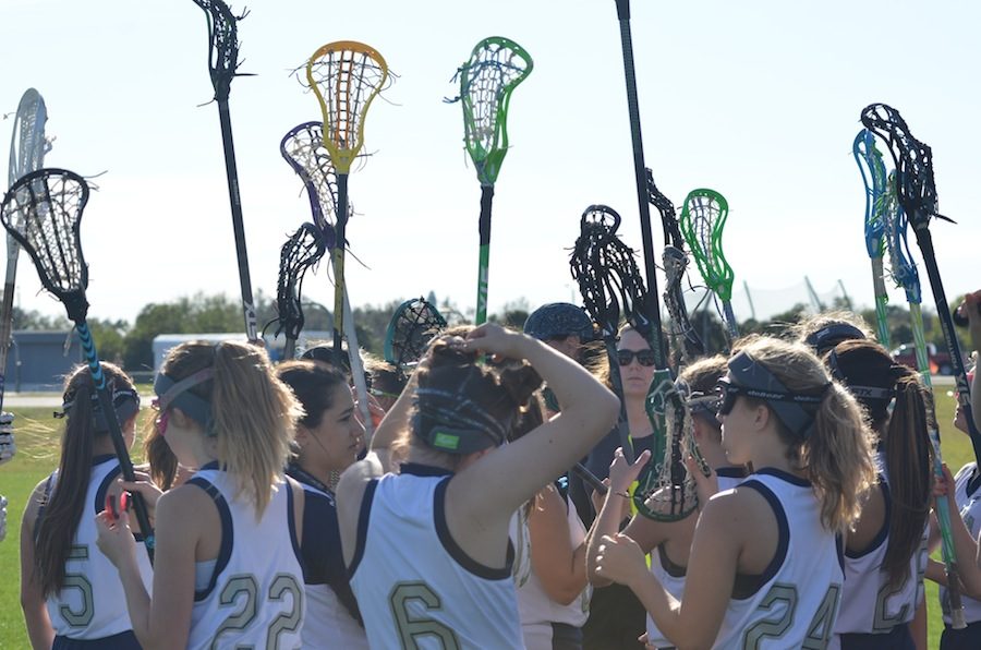 The Lady Wildcats’ lacrosse team gets pumped up before the game.