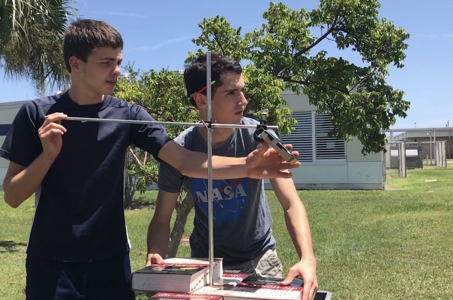 Sophomore Mircea Silaghi and senior Matthew Cahill prepare to capture the eclipse reflection at the end of the day. 