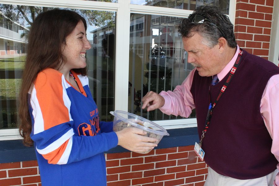 Senior Lily McKnight shares some of her homemade cookies with Principal Rick Fleming on Thursday.