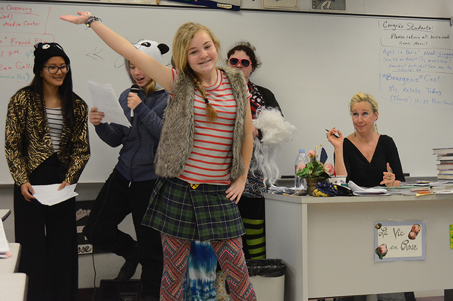 Freshman Cassidy Kuhar walk the runway in a French fashion show as teacher Jennifer Walker looks on.