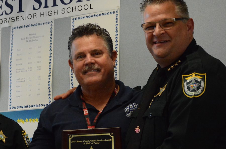 Principal Rick Fleming receives a public service award from Brevard County Sheriff Wayne Ivey.