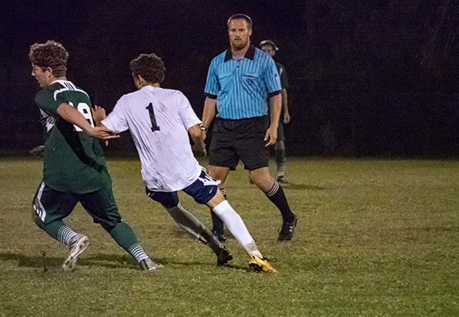Junior Cameron Yeutter tangles with an MCC player Friday night.