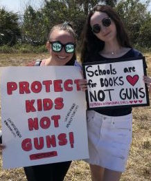 Attending the March for Our Lives protest, sophomores Isabel Burden and Sarah Paylor carry signs in protest to call attention to the government for a reform on guns. “ It’s time for action and for the young people to finally be heard,” Burden said. 