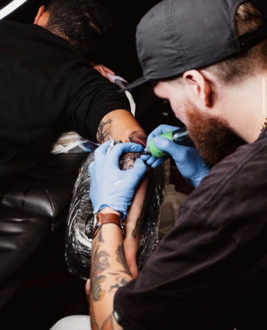 Sam Gill tattooing a client.  