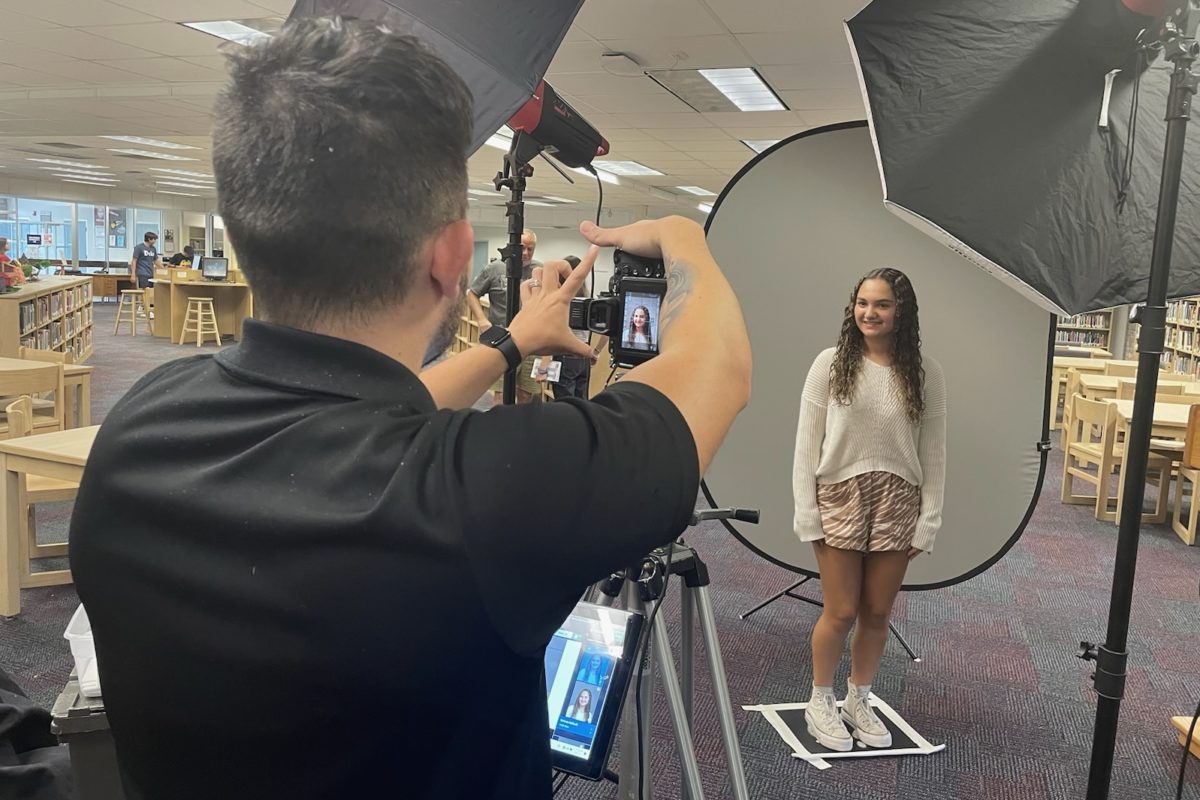 Stefania Raffaelli (11) poses for yearbook picture retakes in the media center Friday morning.  
