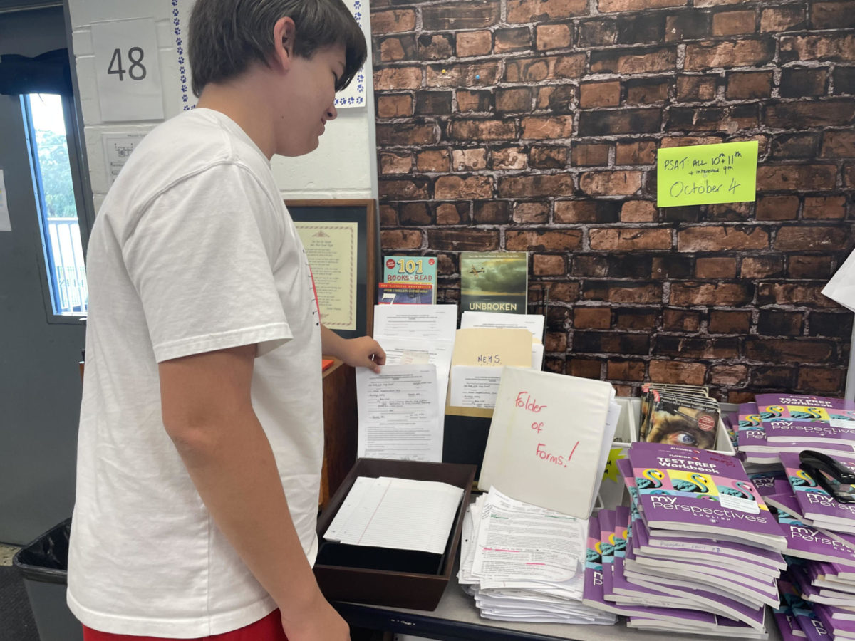 While shuffling through English teacher Tamara Reis’ collection, sophomore Parker Wales searches for a form.