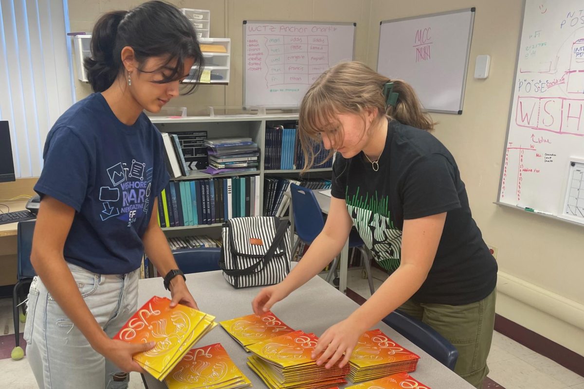 Sophomores Rhea Sinha and Elena Konicki prepare the literary magazines for distribution to English and art teachers Nov. 7. The magazines will be available to students for free Nov. 9 during Power Hour. “Putting the lit mag together took me months of designing and editing,” Sinha said. “Being able to hold it for the first time made all the work worth it.”