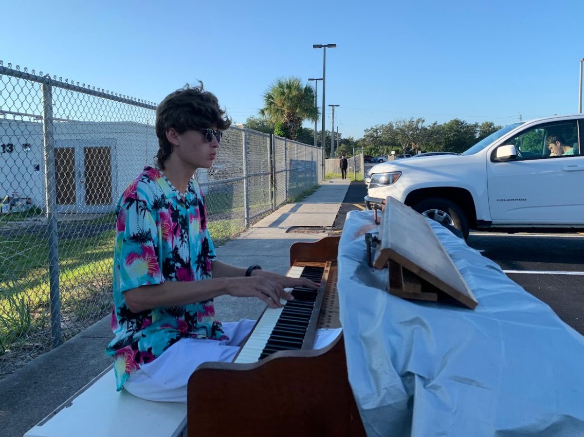 Senior David Vingradov plays Lean on Me by Bill Withers in the senior parking lot on Sept. 18 to kick off the first day of Spirit Week: Barbie versus Oppenheimer. My friend Ioana [Silaghi] spearheaded putting a piano in the parking lot, so I wanted to inaugurate the piano with a song about good friends, he said. 