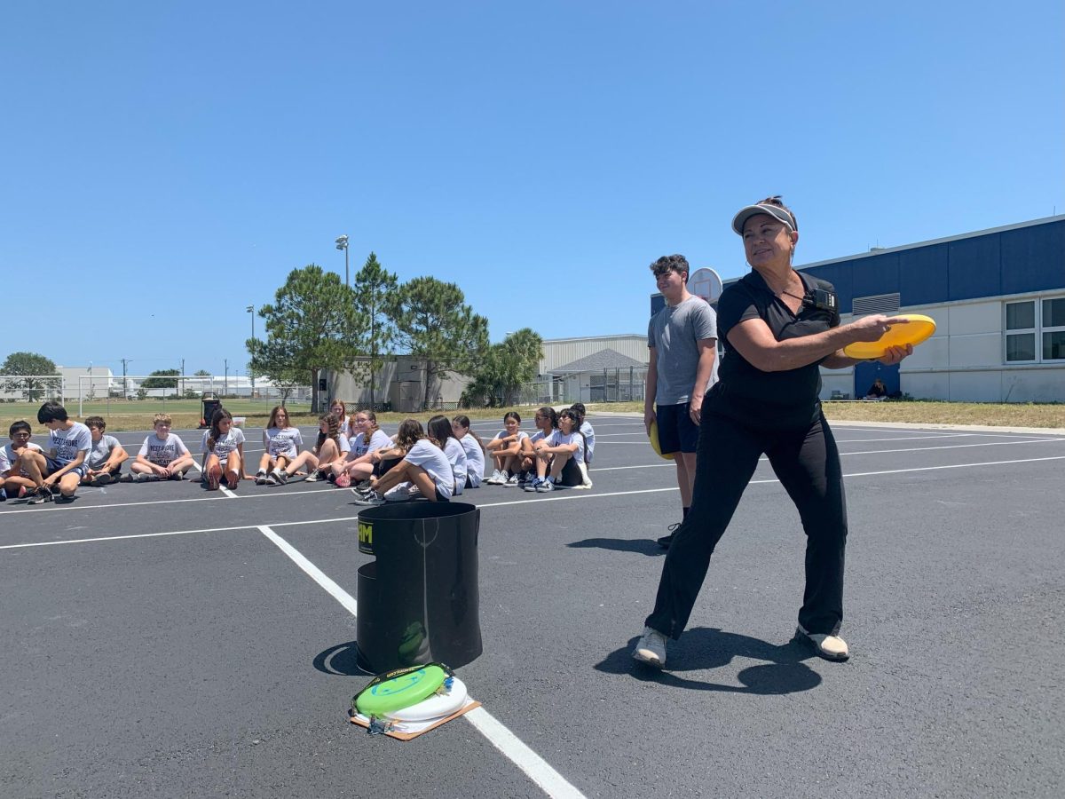 Physical Education teacher Nicole Anagnostis instructs her fifth-period students how to play Kan Jam, a flying disc game,  on April 25.