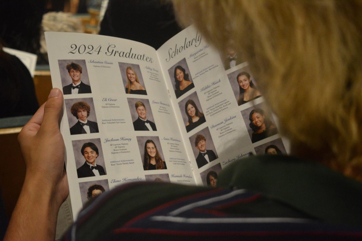 Junior Sean Doran flips through the 2024 graduation program at the Maxwell C. King Center on May 21. It just didnt feel real, Doran said. These people that you knew in high school for the past five years wont be there anymore.
