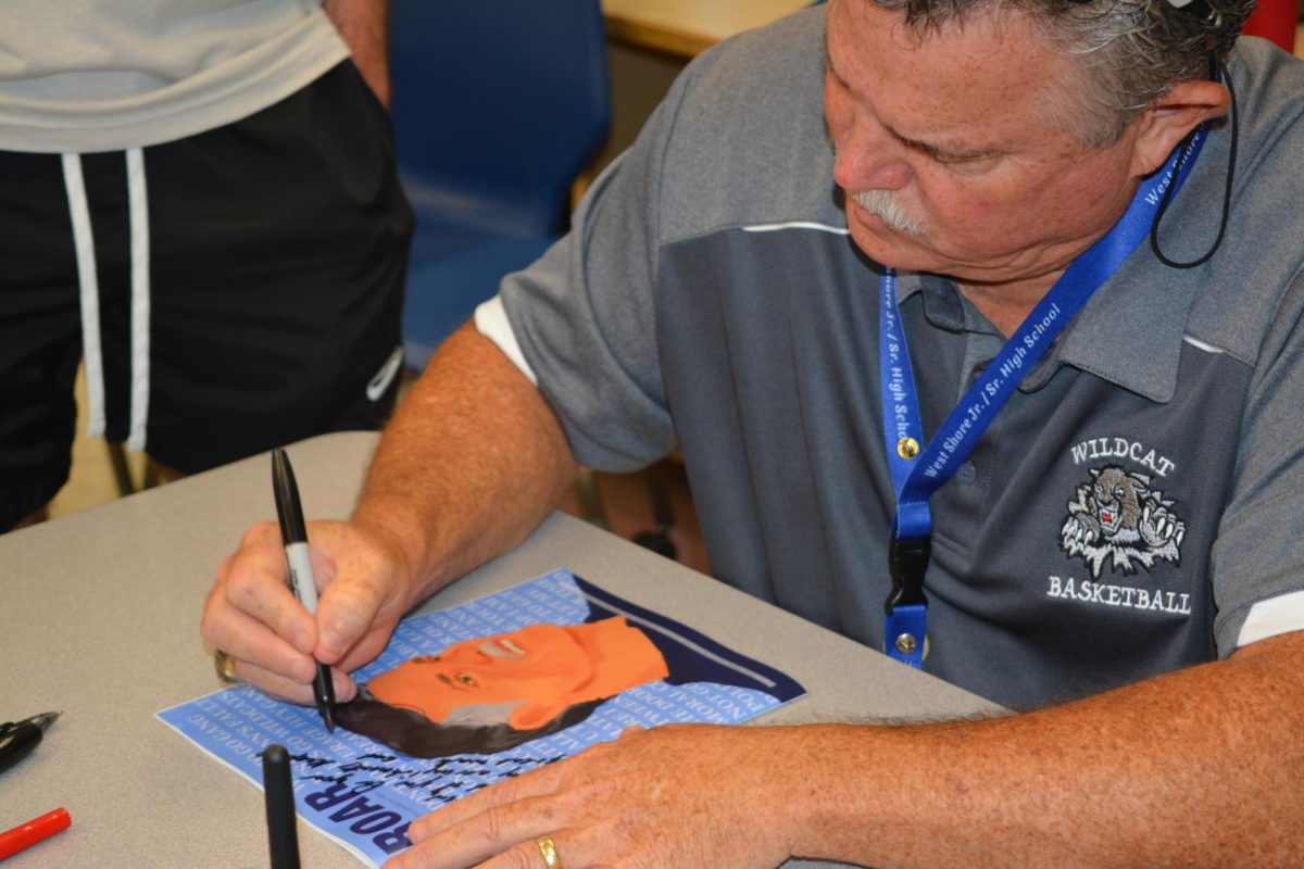 Principal Rick Fleming signs sophomore Drew Newlins copy of the most recent issue of The Roar magazine. It was a very emotional moment, Newlin said. To have a principal who supports the program as much as Fleming does is really special.