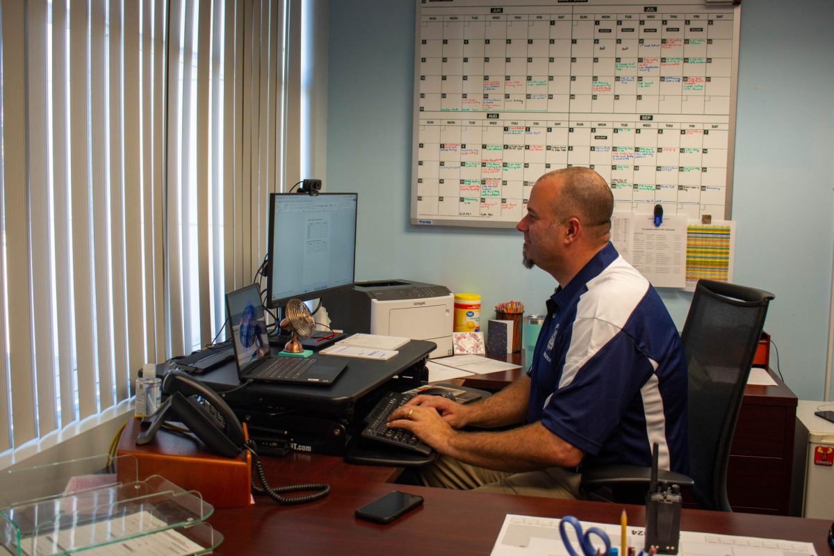 Principal Burt Clark finishes up paperwork in his office during his first official day at West Shore on Aug. 12. "I've felt nothing but excitement for the past two months looking forward to this year," Clark said. "My office is just where I sign papers and send emails, I prefer to be outside in the classrooms, hallways, and at lunch."