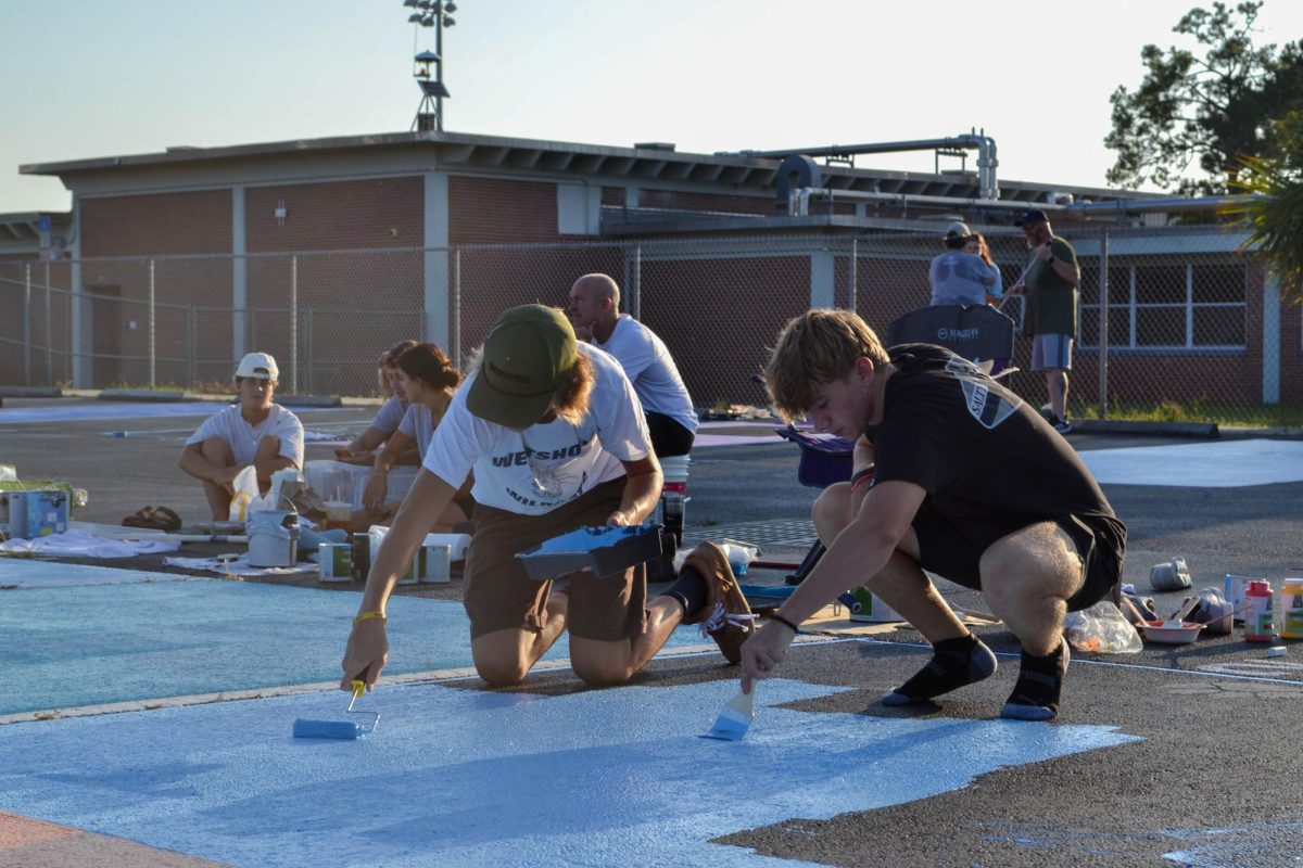 Senior Nate Wittemann paints his own twist on the cover art of Childish Gambino's "STN MTN / Kauai" album on his parking spot in the auditorium parking lot on Aug. 17. "I thought it would be a good representation of who I am, what music I listen to, and how I'm kind of looking into this senior year," Nate said. 