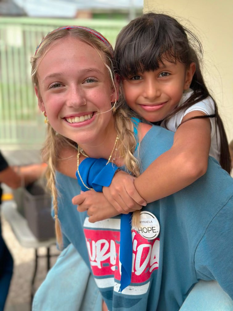 Volunteering at the Hope Center in Pavas, senior Mykaela Brown gives a young girl, Camila, a piggy-back ride.
"Camila would write our names next to each other and chalk with a heart around and that just really impacted me," Brown said.