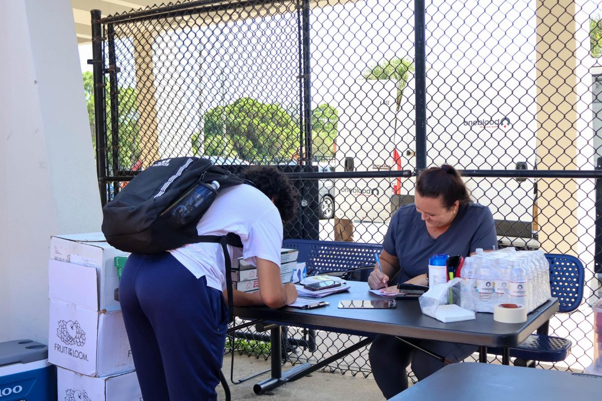 Junior Adam Elbouchti signs up to donate blood through OneBlood outside the cafeteria on Oct. 2. "I'm donating blood mainly for the free food," Elbouchti said. "And to save lives I guess."