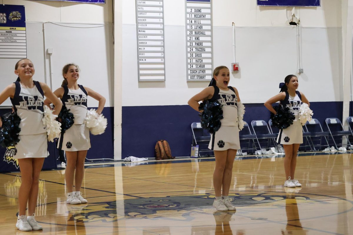 The sideline cheer team performs a routine during the halftime of a basketball game on Dec. 3.