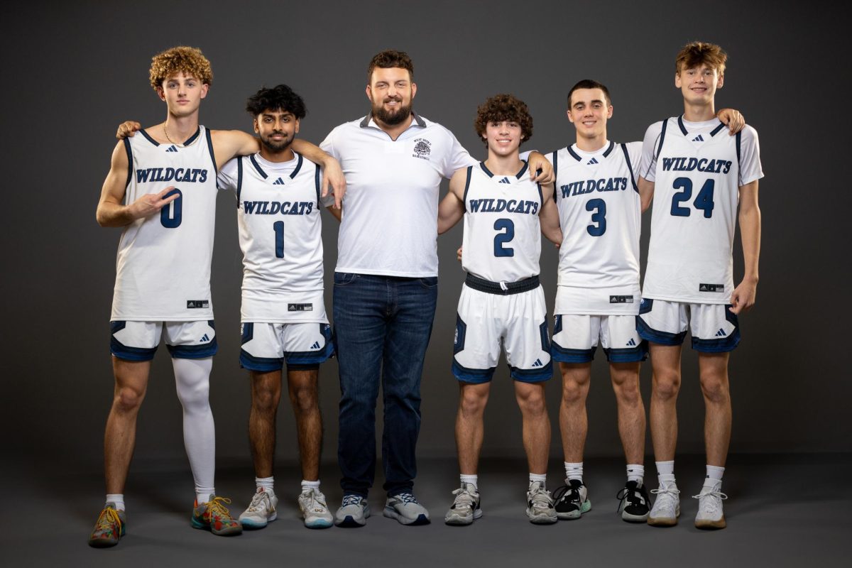 (From left) Seniors Beau Couture, Yogi Patel, coach Corey Burton, Camden Garoust, and Christian Rebec will play their final basketball home game on Jan. 31.