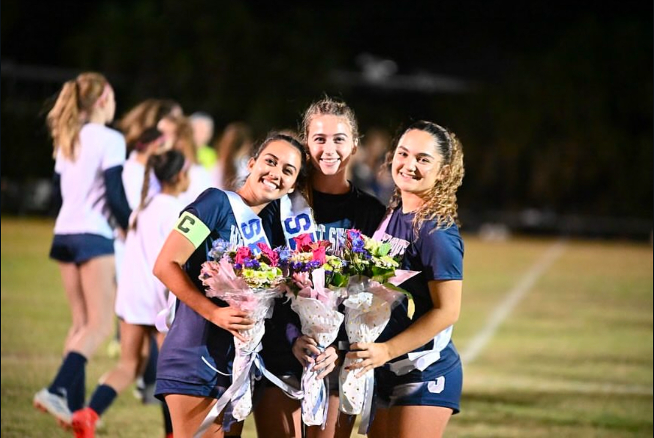 From left, seniors Allison Gunnell, Rebecca Lorigan and Stefania Raffaelli celebrate their girls varsity soccer Senior Night on Dec. 13.