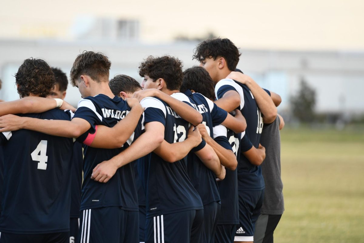 The Boys' Varsity Soccer team form a huddle before a game against Melbourne High School.