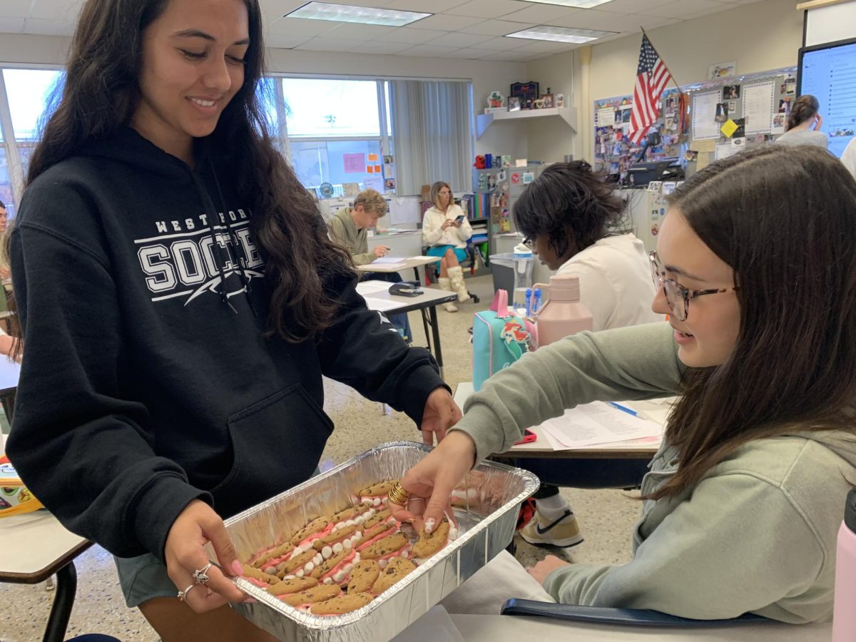 Senior Allison Gunnell shares mouth-shaped cookies with her AP English Literature class for a poetry presentation on Feb. 19. “My poem was ‘In the Waiting Room,’ and it’s about a girl sitting in a dentist’s office, so I thought I’d bring cookies that look like mouths for the class,” Gunnell said. “The best part was everyone’s reactions while they were eating them.”