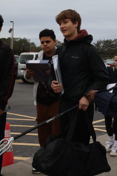 Freshman Alex Kindem, a player on the varsity lacrosse team, waits in line to pass through the metal detectors on Jan. 24, the first day they were implemented.