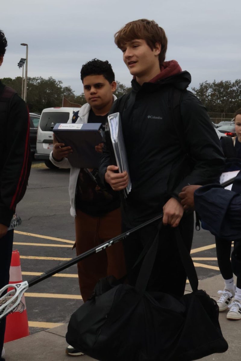 Freshman Alex Kindem, a player on the varsity lacrosse team, waits in line to pass through the metal detectors on Jan. 24, the first day they were implemented.