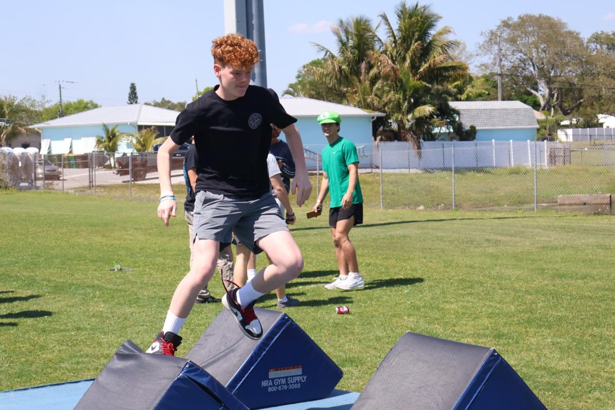 Eighth grader Evan Wilkerson runs across the obstacle course.