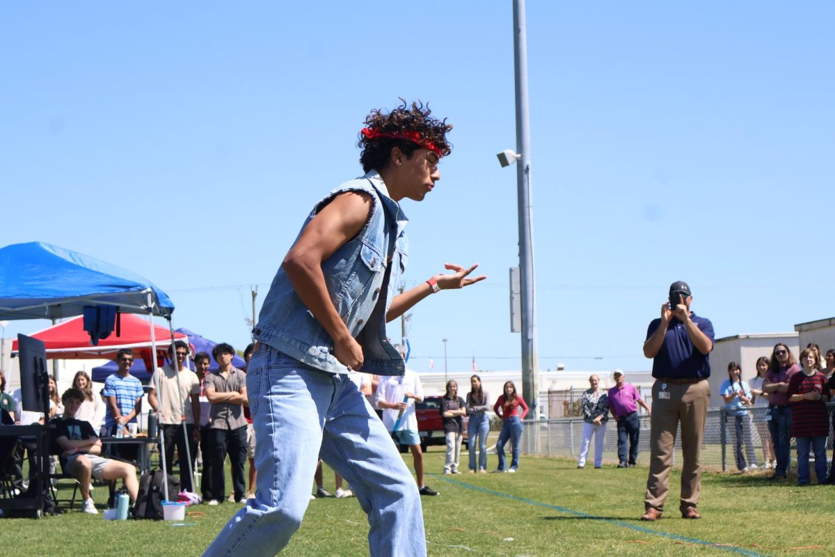 Senior Aiden Zaiden strums an imaginary guitar while donning all denim.