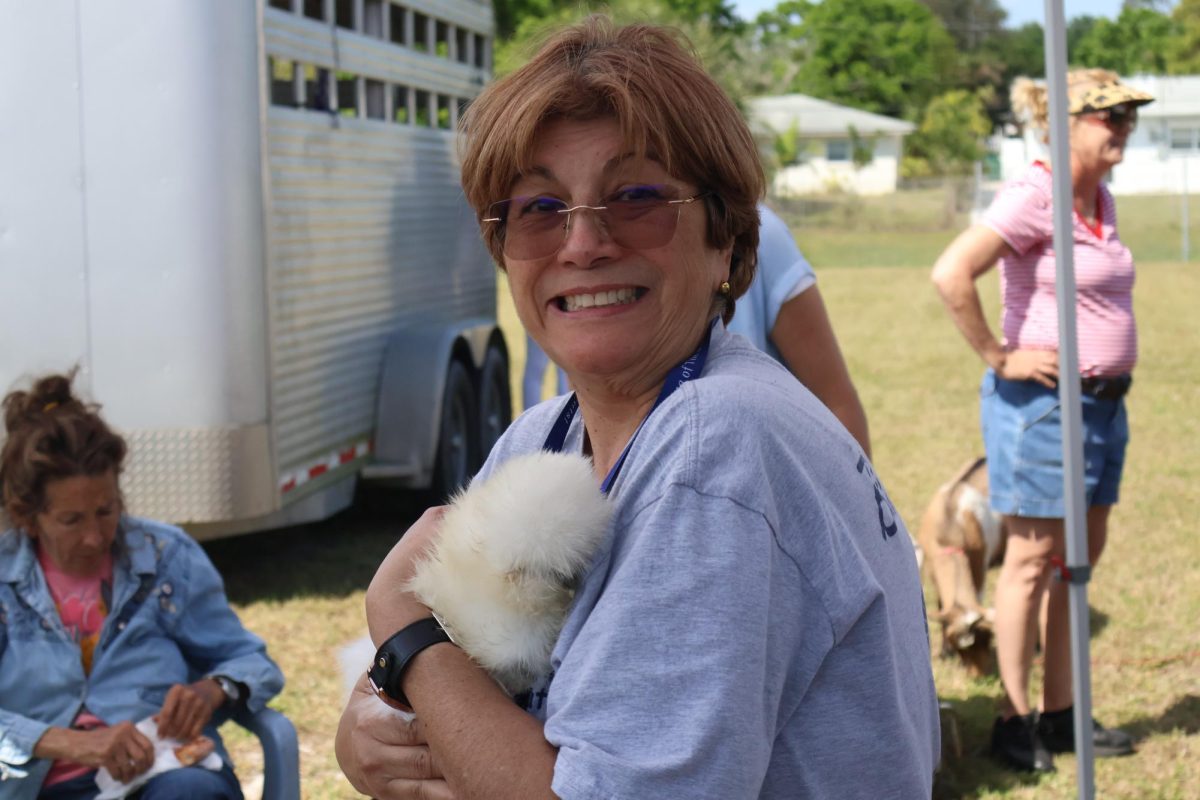 Spanish teacher Awilda Marti holds a chicken at the petting zoo.