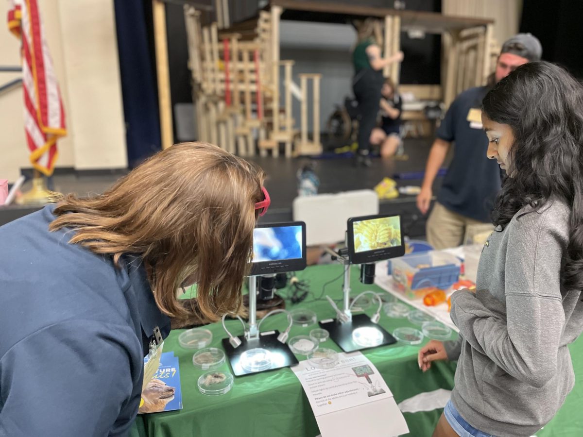 Freshman Anisha Chityal visits a Brevard Zoo booth at STEM Night on March 26. “My favorite part is always being able to interact with new people and show them STEM-related things the zoo is doing,” Brevard Zoo conservation learning board member Audrey Smith said. Students interacted with Virtual Reality, dry ice, 3D models and more.
