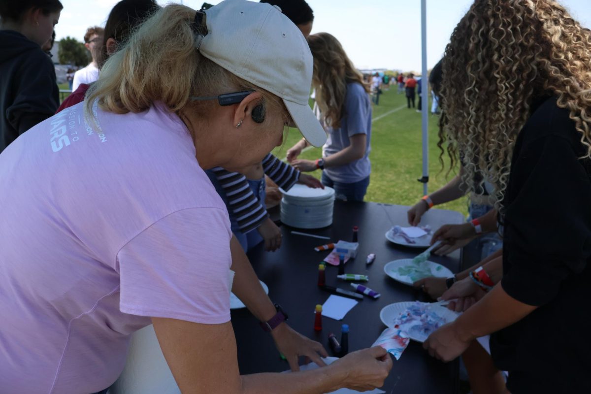 Chemistry teacher Dawn Gregor helps students create shaving cream art using food dye. “We’re trying to educate kids on chemistry and find interest in Chem Club as a whole,” junior Abigail Floyd said. “We’re letting them water-marble shaving cream and make art to show everyone what we’re about.”
 