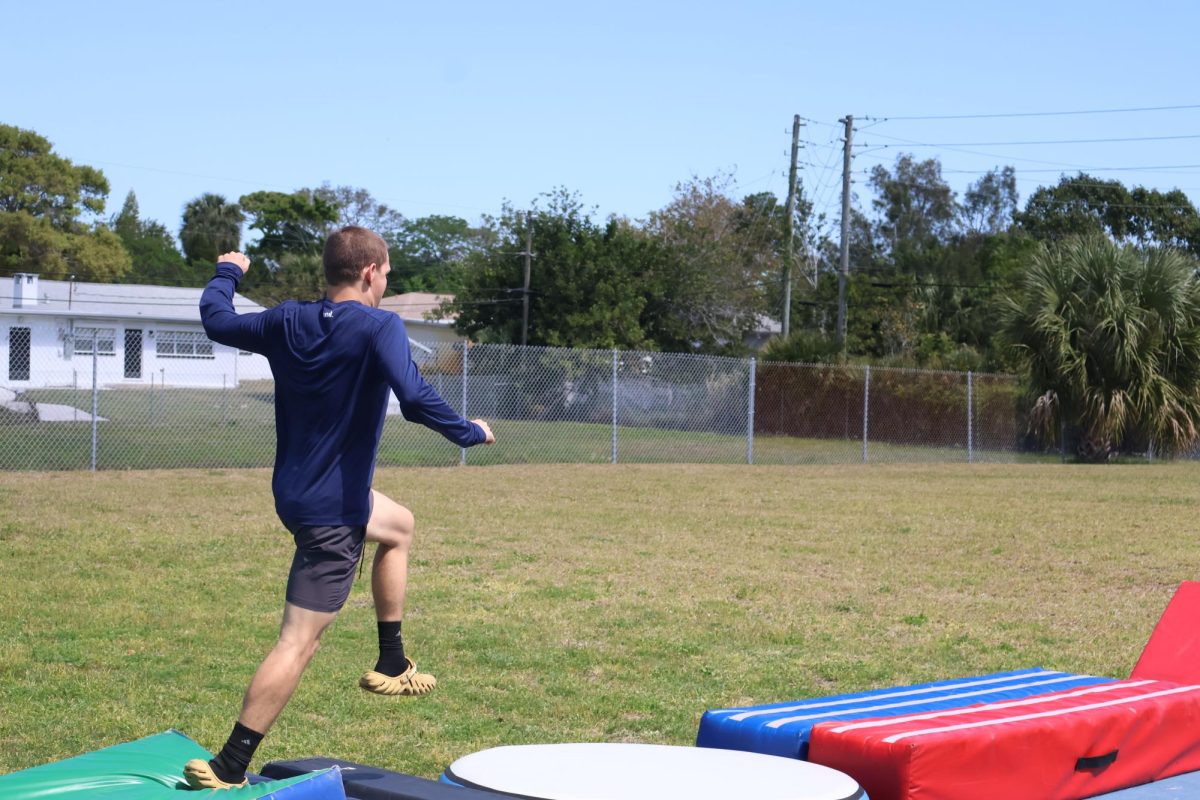 Junior Luke Markos runs across the obstacle course.
