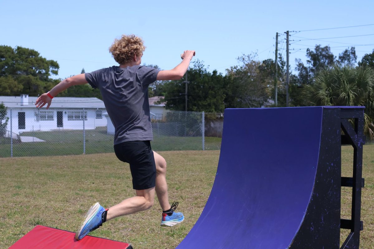 Junior Jackson Theiler jumps to reach the end of the obstacle course.