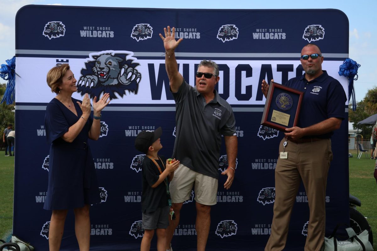 Former Principal Rick Fleming, who retired last year after being principal of the  school for 17 years, waves to the crowd. “This event is awesome, but they should save it for years when we get blue ribbons,” junior Kellyn Hoffmann said. “It would make the event even more special.”