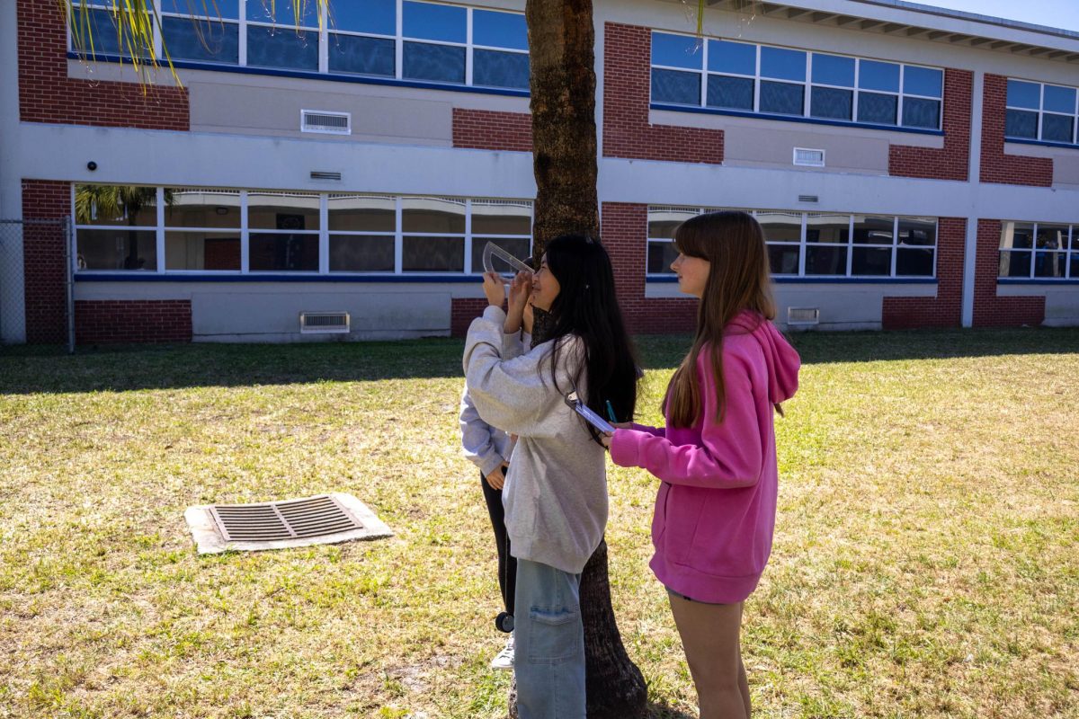 Ethan Hacker’s geometry class measures the height of West Shore buildings using protractors and trigonometry skills on March 12. “We’re learning how to apply [trigonometry] to real life,” Freshman Victoria Ye said. “It’s quite fun to be outside of the classroom.”