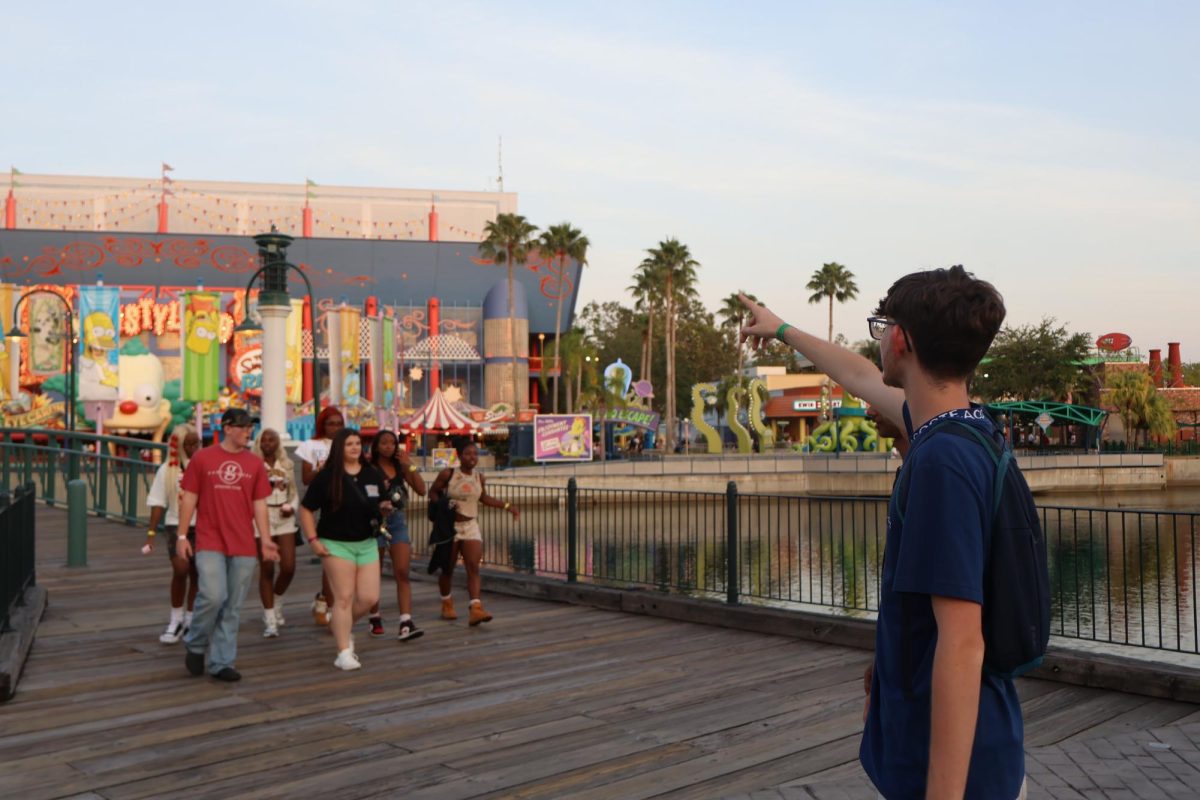 Senior Leo Esbelin points towards the Krustyland section of the Universal Studios park at Grad Bash on April 25. "It, was great," Esbelin said, "and I enjoyed hanging out with my friends."