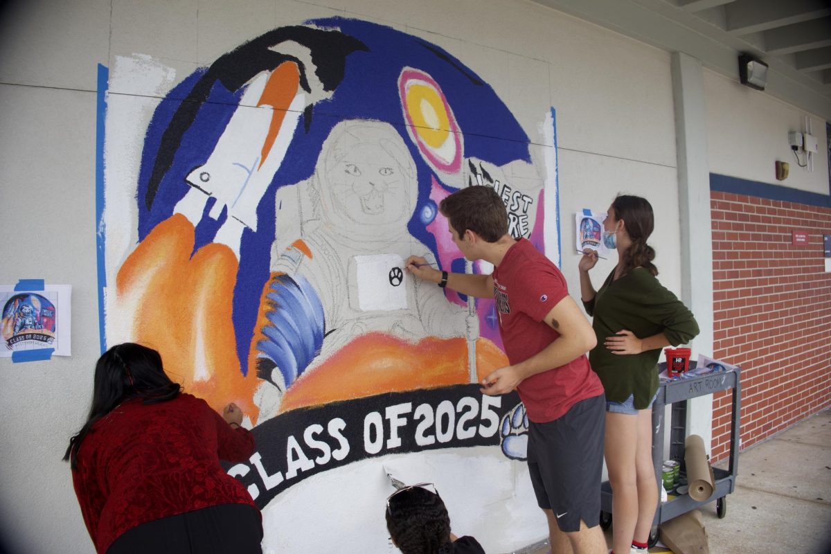 Students from National Art Honor Society paint the Class of 2025 mural on April 30. "I know the seniors do a lot," sophomore Sophia Menendez said, "so it's nice to do something for them so they know how much they are appreciated and how much they will leave their mark on the school."