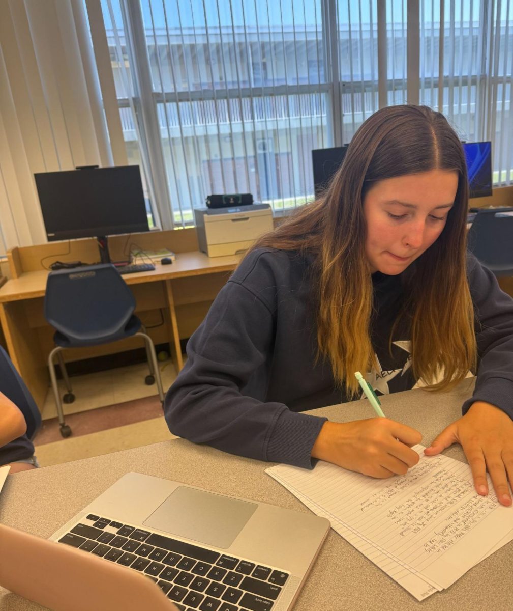 Sophomore Reagan Hill studies for her AP United States History exam. Hill reviews by looking over her old notes, then writing down what she remembers.