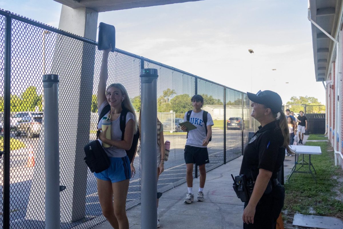 School Resource Officer Valerie Butler (right) monitors the metal detector on Aug. 13. “I think [the students have] been adjusting really well," Butler said. "It's been a great week. We've had no issues, no snafus. Everything's been running smoothly, and we've been getting kids to class on time.”