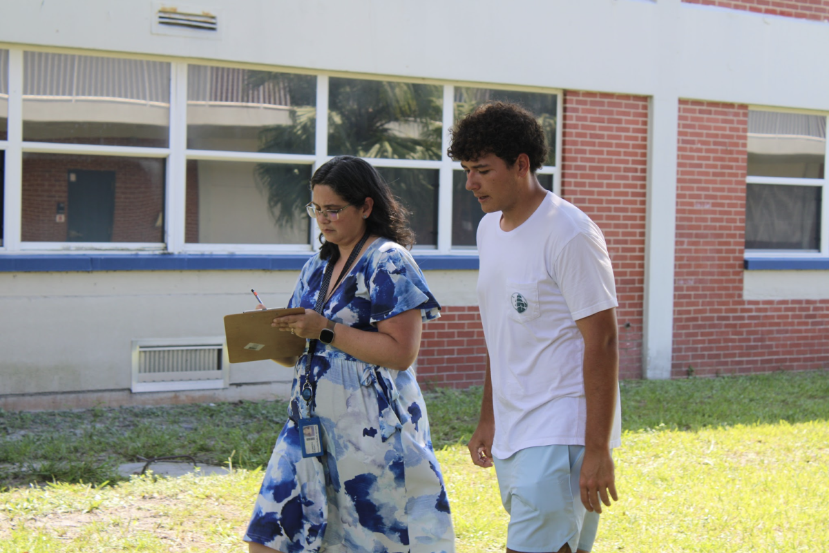 AP Research teacher Alexandra Stewart (left) and senior Liam Corry brainstorm research project ideas on Aug. 27. “Walking around, instead of being cooped up in a classroom, can help get more expression of ideas and more creativity,” Corry said. Stewart had students walk alongside a partner and share their ideas in front of Building 3.