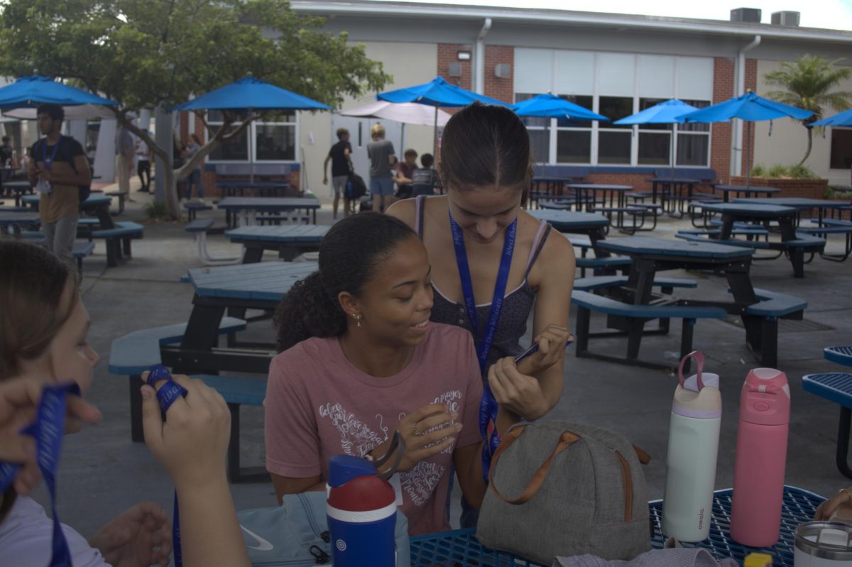 Juniors Adriah Mossiah (left) and Artemis Theodoropoulos look at their new IDs on Aug. 29.
