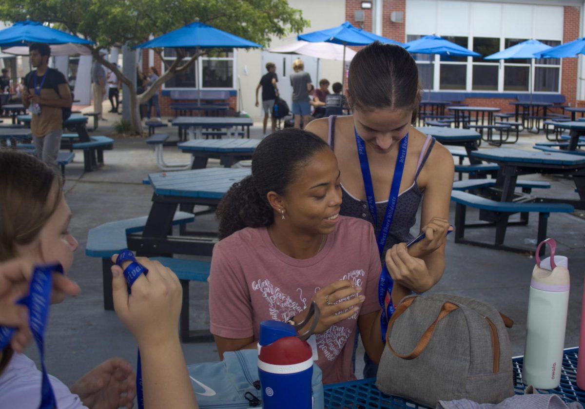 Juniors Adriah Mossiah (left) and Artemis Theodoropoulos look at their new IDs on Aug. 29.