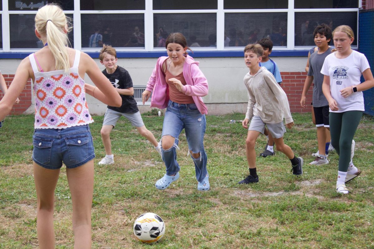 Seventh grader Kerry Lerch plays soccer during Power Hour B on Sept. 23.  “[Playing soccer] helps me focus more throughout the day,” Lerch said. “If I have a lot of energy [during class], then I'm looking around and everything, and it's distracting. So if I'm focusing on soccer during that time, then later I get to focus on school, and it helps me transition.”