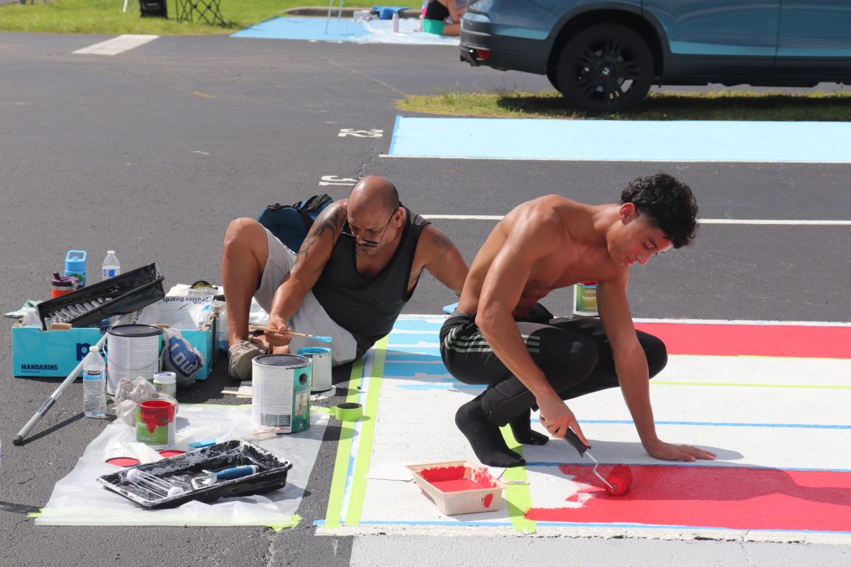 Senior Jeremiah Matias (right) paints his parking spot with his dad on Sept. 7.